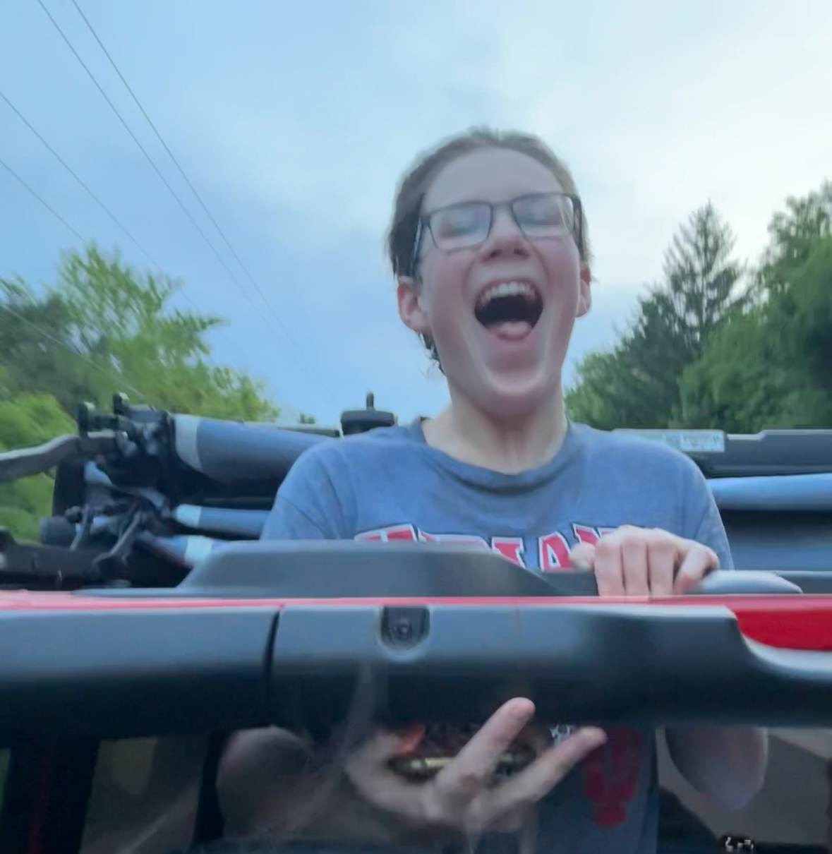 Student smiling in the back of a Jeep after club